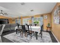 Well-lit dining room featuring a long table, black chairs, and an open-concept layout at 2454 Whitehorse St, Deltona, FL 32738