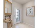 Inviting entryway featuring tile flooring, decorative mirror and front door with decorative glass panes at 2526 Winsome Way, Davenport, FL 33896