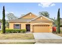 Inviting home exterior featuring a two-car garage and manicured lawn at 281 Edisto Pl, Apopka, FL 32712