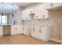 Modern kitchen featuring white cabinets, a stylish backsplash, and stainless steel faucet at 313 Mandrake St, Orlando, FL 32811