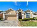 Beautiful one-story home boasts a well-maintained lawn, brick driveway, and a convenient two-car garage at 322 High Vista, Davenport, FL 33837