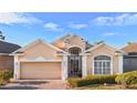 Inviting one-story residence showcasing a lush lawn, brick driveway, and an attached two-car garage at 322 High Vista, Davenport, FL 33837