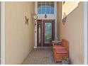 View of the front entryway that features a seating area, red door, and beautiful sidelight windows at 322 High Vista, Davenport, FL 33837