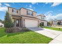 Inviting home with a well-manicured lawn and a spacious driveway leading to an attached two-car garage at 3566 Southern Cross Loop, Kissimmee, FL 34744