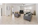 Spacious living room with neutral tile flooring, a ceiling fan, and large windows for natural light at 3566 Southern Cross Loop, Kissimmee, FL 34744