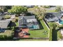 Aerial view of a home with a screened-in pool, spacious backyard, and play equipment at 460 Forestwood Ln, Maitland, FL 32751