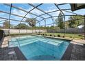 Screened-in pool with clear blue water, surrounded by brick pavers and lush landscaping at 460 Forestwood Ln, Maitland, FL 32751