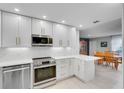 Bright kitchen showcasing white cabinetry, stainless steel appliances, and a seamless connection to the dining area at 611 Aldama Ct, Ocoee, FL 34761