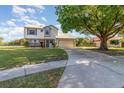 Inviting two-story home with a well-kept lawn and an expansive driveway leading to a two-car garage at 8155 Brocatel Ct, Orlando, FL 32822