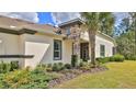 Well-maintained home showcasing a manicured lawn, lush landscaping, and tasteful stone accents around the windows at 842 Aldenham Ln, Ormond Beach, FL 32174