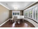 Bright living room with dark wood floors, bay windows, plantation shutters, and stylish chandelier at 916 Puma Trl, Winter Springs, FL 32708