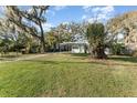 Front lawn view of a quaint home with mature trees and landscaping at 1140 W Seminole Trl, Bartow, FL 33830