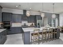 Modern kitchen featuring gray cabinetry, stainless steel appliances, a center island, and stylish pendant lighting at 1593 Evening Summit Cir, Minneola, FL 34715