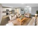Bright living room open to kitchen, featuring modern furniture, wood floors, and plenty of natural light at 1613 Reflection Cv, St Cloud, FL 34771