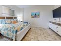 Coastal-themed bedroom with a comfortable bed, a flat-screen TV, and stylish decor creates a relaxing retreat at 1705 S Atlantic Ave # 402, New Smyrna Beach, FL 32169