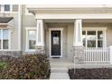 Inviting front porch with stone accents on the pillars and a covered entrance to the home at 1856 Cross Prairie Pkwy, Kissimmee, FL 34744