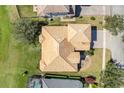 Aerial view of home with tile roof, green lawn, and paver driveway at 1950 Windward Oaks Ct, Kissimmee, FL 34746