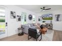 Bright living room with hardwood floors, grey sofa, modern art, and plenty of natural light at 1987 Peel Ave, Orlando, FL 32806
