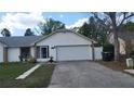 Well-maintained home with a two-car garage and a driveway, alongside a well-kept lawn at 272 Loma Bonita Dr, Davenport, FL 33837