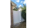 A white fence separating the property from the neighbors, with a brick corner accent at 272 Loma Bonita Dr, Davenport, FL 33837