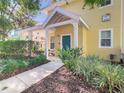 Charming condo exterior featuring a covered porch with vibrant landscaping and colorful facade at 3002 Bonfire Beach Dr # 202, Kissimmee, FL 34746