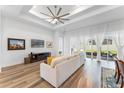 Bright living room with hardwood floors, a large couch, and sliding glass doors to the backyard at 3186 Sailing Pier Ave, Winter Garden, FL 34787