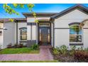 Elegant front door with sidelights, flanked by manicured landscaping and a brick walkway at 3351 Pine Timber Pt, Oviedo, FL 32765