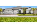 Beautiful one-story home with a three-car garage, well-maintained lawn and tropical landscaping at 3351 Pine Timber Pt, Oviedo, FL 32765