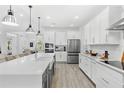 Bright, modern kitchen features white cabinets, stainless steel appliances, and a spacious center island at 3351 Pine Timber Pt, Oviedo, FL 32765