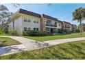 A welcoming condo complex with lush landscaping and well-maintained sidewalks on a bright, sunny day at 3800 Saxon Dr # 19B, New Smyrna Beach, FL 32169
