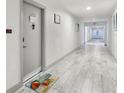 A well-lit hallway with tile flooring, an exit sign, and wall decorations near the unit entrance at 3800 Saxon Dr # 19B, New Smyrna Beach, FL 32169