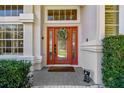 Elegant front entrance with a red door, transom window, sidelights, and decorative wreath at 442 Devon Pl, Lake Mary, FL 32746