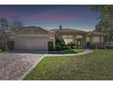 Charming one-story home with lush green lawn and meticulously landscaped front yard at twilight at 442 Devon Pl, Lake Mary, FL 32746