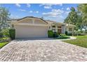 Charming single-story home featuring a brick driveway, well-maintained landscaping, and an attached two-car garage at 442 Devon Pl, Lake Mary, FL 32746