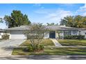 Charming single-story home with a manicured front yard and a paved walkway to the front door at 4913 E Wind St, Orlando, FL 32812