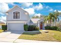 Charming two-story home featuring a well-manicured lawn and an attached two-car garage at 511 Coventry Rd, Davenport, FL 33897