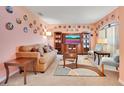 Cozy living room with neutral tones, plush seating, and unique decorative plates adorning the walls at 511 Coventry Rd, Davenport, FL 33897