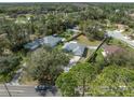 An aerial view of the property surrounded by mature trees, a pool, and nearby houses at 607 S Glencoe Rd, New Smyrna Beach, FL 32168