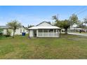 Back view of single-story house with fenced-in porch and green lawn at 624 Illinois Ave, St Cloud, FL 34769