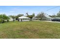 Spacious backyard with a well-manicured lawn and mature trees, offering ample space at 624 Illinois Ave, St Cloud, FL 34769