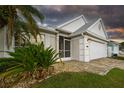 Charming single-story home featuring a well-manicured lawn, palm trees, and a two-car garage at 6425 Streamport Dr, Orlando, FL 32822