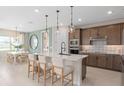 Modern kitchen with a center island, pendant lighting, stainless steel appliances, and a breakfast nook at 6920 Dappled Oak Way, Orlando, FL 32829