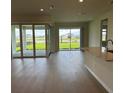 Bright open-concept living area with hard floors and sliding glass doors to a screened porch at 6920 Dappled Oak Way, Orlando, FL 32829