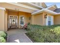 Inviting front entrance with a charming wooden door, colorful plants and brick pathway at 8712 Sw 83Rd Cir, Ocala, FL 34481