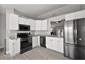 Modern kitchen featuring sleek, stainless steel appliances and bright white cabinets at 12419 Eryn Ct, Clermont, FL 34711