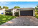 Charming home featuring a well-manicured lawn, gray trim, and a two car garage at 1244 Spinnaker Dr, Lakeland, FL 33805