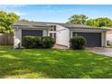 Charming home featuring a well-manicured lawn, gray trim, a two car garage, and a modern entrance at 1244 Spinnaker Dr, Lakeland, FL 33805