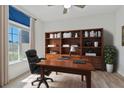 Bright office featuring custom built-in shelving, a large window, and a comfortable workspace at 1407 Leitrim Loop, Apopka, FL 32703