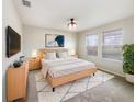 Well-lit main bedroom with a cozy rug, neutral tones, and ample natural light from the large windows at 15120 Zenith Ave, Mascotte, FL 34753