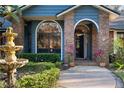 Attractive home exterior with brick accents, a fountain, and an arched doorway at 2614 W Ponkan Rd, Apopka, FL 32712